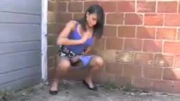 Sophisticated dark-haired woman urinating and grinning
