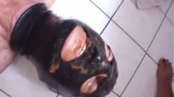 Female defecating on a male in the bathroom on the ground